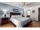 Comfortable bedroom featuring a ceiling fan, two bedside tables, and a doorway to the ensuite bathroom at 9243 W Kimberly Way, Peoria, AZ 85382