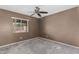 Bedroom with ceiling fan, carpet flooring and window with backyard views at 1110 E Utopia Rd, Phoenix, AZ 85024