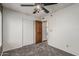 Bedroom with carpet, ceiling fan, closet and wooden door to hallway at 1110 E Utopia Rd, Phoenix, AZ 85024