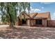 Charming single-story home with desert landscaping, mature tree, and covered front porch at 1110 E Utopia Rd, Phoenix, AZ 85024