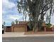 Charming single-story home with desert landscaping, a two-car garage, and a mature shade tree at 1110 E Utopia Rd, Phoenix, AZ 85024