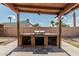 Outdoor grill area with built in counters and storage with a view of backyard at 1110 E Utopia Rd, Phoenix, AZ 85024