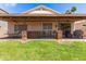 Wide backyard shot features a large covered patio, a hot tub, green grass, landscaping, and a view of the neighborhood at 11411 W Dana Ln, Avondale, AZ 85392