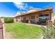 A large covered patio offers an outdoor living space and overlooks lush green lawn and landscaping in this backyard scene at 11411 W Dana Ln, Avondale, AZ 85392
