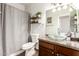 This bathroom features wood-look tile floors and a glass bowl sink atop a wooden vanity with two decorative floating shelves at 11411 W Dana Ln, Avondale, AZ 85392
