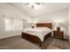 Comfortable bedroom with a ceiling fan, large window, and a spacious carpeted area at 11411 W Dana Ln, Avondale, AZ 85392