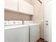 A laundry room offers a stacked washer and dryer unit with white cabinets above and tile flooring at 11411 W Dana Ln, Avondale, AZ 85392