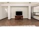 A spacious living area showing a TV, tile floors, and arched doorway to the front entrance at 11411 W Dana Ln, Avondale, AZ 85392