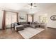 Spacious living room featuring tile floors, modern ceiling fan and view of the dining room at 11411 W Dana Ln, Avondale, AZ 85392