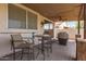 Covered patio shows an outdoor table and chairs, a ceiling fan, and a grill on a brick surface with access to the yard at 11411 W Dana Ln, Avondale, AZ 85392