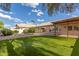 Back yard with grass, bushes and brick covered patio and blue sky at 13414 E Cindy St, Chandler, AZ 85225