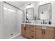 Bright bathroom with dual sink vanity, wood cabinets, black hardware, shower and neutral tile at 13414 E Cindy St, Chandler, AZ 85225