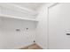Bright laundry room with built-in shelving and modern wood-look flooring at 13414 E Cindy St, Chandler, AZ 85225