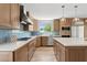Well-lit kitchen boasts custom cabinetry, stainless steel appliances, and a center island with quartz countertop at 14802 N 3Rd Ave, Phoenix, AZ 85023