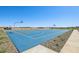 Community blue basketball court with hoops and a paved walkway, set against a clear blue sky at 15792 W Beryl Ave, Waddell, AZ 85355
