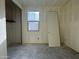 A bedroom under construction featuring unfinished concrete floors, a door, a window, and a closet at 15792 W Beryl Ave, Waddell, AZ 85355