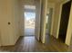 Bright foyer with wood-look tile flooring, neutral walls, and an open doorway, leading to a room with a window at 15792 W Beryl Ave, Waddell, AZ 85355
