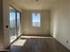 An open-concept living area with sliding glass doors and wood-look tile flooring, ready for finishing touches at 15792 W Beryl Ave, Waddell, AZ 85355