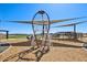 Community playground with rocket ship climber and shade canopies on a wood chip base under a blue sky at 15792 W Beryl Ave, Waddell, AZ 85355