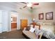 Comfortable bedroom features neutral walls, a sitting sofa, artwork, and a view into the bathroom at 1623 E Krystal St, Casa Grande, AZ 85122