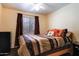Modest bedroom with striped comforter, wood furniture, and a window with brown curtains at 1623 E Krystal St, Casa Grande, AZ 85122