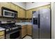 Well-lit kitchen features wooden cabinets, stainless steel appliances, and a tiled backsplash at 1623 E Krystal St, Casa Grande, AZ 85122
