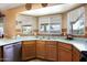 Bright kitchen with stainless steel dishwasher, wood cabinetry and double sink overlooking the backyard at 1623 E Krystal St, Casa Grande, AZ 85122