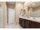 Bright bathroom features a double sink vanity with dark wood cabinets and white countertop, with tile flooring at 19834 N Tammy St, Maricopa, AZ 85138