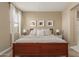Bright bedroom features a wood bed frame with white bedding, white curtains, and framed artwork at 19834 N Tammy St, Maricopa, AZ 85138
