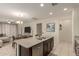 Open concept with kitchen island featuring stainless steel dishwasher with views to dining and living spaces at 19834 N Tammy St, Maricopa, AZ 85138
