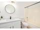 Clean bathroom with modern fixtures, including a vanity with marble countertop, round mirror, and a shower-tub combo at 2030 S 86Th Dr, Tolleson, AZ 85353