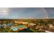 Scenic aerial view showcasing the community's pool, clubhouse, lake, and lush landscaping under a beautiful rainbow at 21150 N Evergreen Dr, Maricopa, AZ 85138