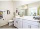 Bright bathroom featuring white cabinets and a large mirror at 21150 N Evergreen Dr, Maricopa, AZ 85138