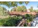 Charming bridge over a waterway with lush foliage and vibrant flowers at 21150 N Evergreen Dr, Maricopa, AZ 85138