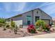 Charming home featuring desert landscaping with vibrant bougainvillea bushes and a decorative dry creek bed at 21150 N Evergreen Dr, Maricopa, AZ 85138