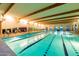Beautiful indoor pool with clear water, marked lanes, wood beam ceilings and expansive windows for a refreshing swim at 21150 N Evergreen Dr, Maricopa, AZ 85138