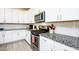 Modern kitchen with white cabinetry, stainless steel appliances, granite countertops, and a tile backsplash at 21150 N Evergreen Dr, Maricopa, AZ 85138