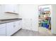 Laundry room with white cabinetry, countertop space, and convenient access to a walk-in storage area at 21150 N Evergreen Dr, Maricopa, AZ 85138