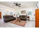 Spacious living room featuring comfortable leather sofas, a ceiling fan, and tile flooring at 21150 N Evergreen Dr, Maricopa, AZ 85138