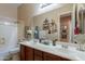 Bathroom with a double sink vanity, decorative mirrors, and a shower-tub combination at 2160 E Kenwood St, Mesa, AZ 85213