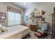 Bedroom with a floral-patterned quilt, floral window valence, wooden furniture, and eclectic wall decor at 2160 E Kenwood St, Mesa, AZ 85213