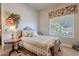 Cozy bedroom with carpet flooring, a floral-patterned quilt bedspread, and a window with blind coverings at 2160 E Kenwood St, Mesa, AZ 85213