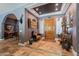 Grand foyer featuring stone floors, a decorative wood door, and elegant furnishings at 2160 E Kenwood St, Mesa, AZ 85213
