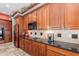 Well-appointed kitchen with cherry wood cabinets, granite countertops, and modern appliances, offering style and functionality at 2160 E Kenwood St, Mesa, AZ 85213