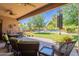 Inviting covered patio with comfortable seating overlooking a lush backyard and sparkling pool, perfect for outdoor relaxation at 2160 E Kenwood St, Mesa, AZ 85213