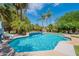 Beautiful backyard pool featuring palm trees and a built-in water feature, perfect for relaxation and entertainment at 2160 E Kenwood St, Mesa, AZ 85213