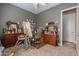 An eclectic room features an easel, a desk, a dresser, a mirror, and grey walls at 2160 E Kenwood St, Mesa, AZ 85213