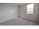 Neutral-toned bedroom with plush carpet, natural light, and clean, minimalist aesthetic at 22085 N Rummler Ln, Maricopa, AZ 85138