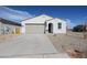 Charming single-story home featuring a desert-style gravel yard, a two-car garage and a welcoming arched entryway at 22085 N Rummler Ln, Maricopa, AZ 85138