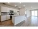 The bright kitchen features white cabinets, stainless appliances, tile backsplash, and wood-look tile floors at 22085 N Rummler Ln, Maricopa, AZ 85138